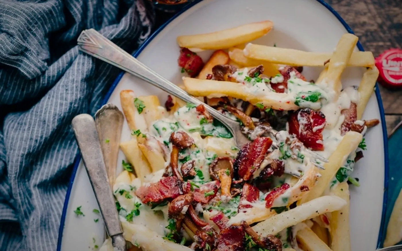 Papas cargadas con queso, tocino y jalapeños, sobre fondo oscuro